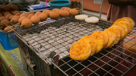 Vender selling grilled eggs thai style local market at temple in Bangkok , Asia , Thailand