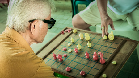 Unidentified old man is racing chess at Bangplat Bangkok , Thailand. The chess is favorite activity of thai old people in here.のeditorial素材