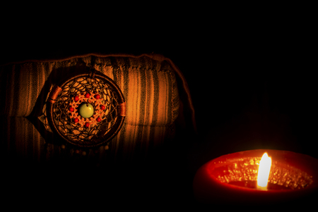 In dark . Vintage style image of dreamcatcher on classics pillow and candle light. sweet dream.の写真素材
