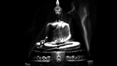 Black and whihte style of Buddha statue and Candle smoke with light dark background . buddha image used as amulets of Buddhism religion.の写真素材