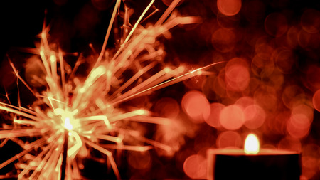 Blur image style. Christmas and New Year party sparkler and Candle flame light at night with abstract circular bokeh background Christmas lights.の写真素材