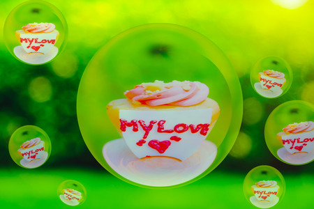 Love pink Cupcake with  inscription note - MY LOVE with glass ball effect and blurred Greem garden...