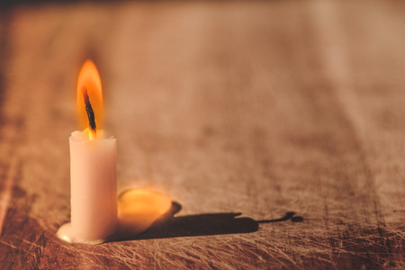 Candle flame light on old Wood  with lighting on window.の写真素材