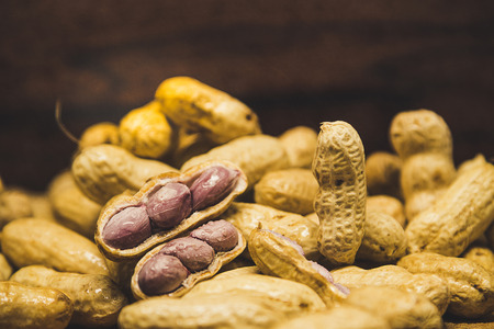 Vintage style image of boiled peanuts peel out on wood background.
