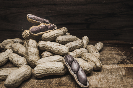 Vintage style image of boiled peanuts peel out on wood background.