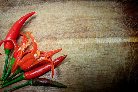 Fresh red hot chili peppers on rustic wood background.の写真素材