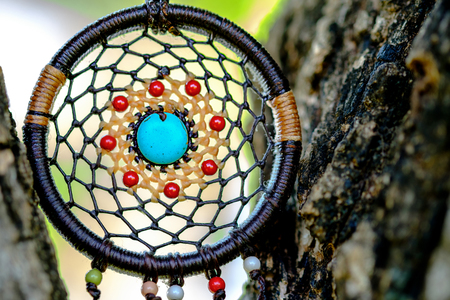 Vintage image of Dreamcatcher on the tree with green natural blurred bokeh background.の写真素材