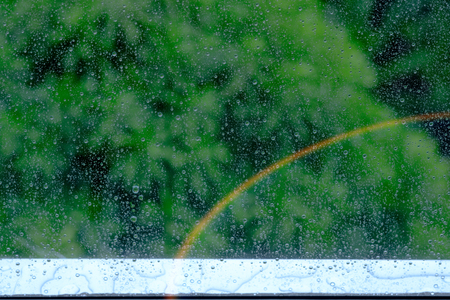Rain / Water drop of rain on glass window with Sunlight and rainbow effect ,the rainy season.の写真素材