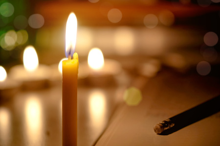 Candles light with blurred book background in the Church.の写真素材
