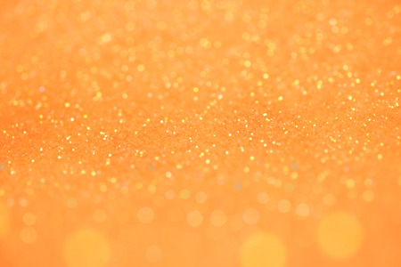 Bright and abstract blurred orange  bokeh background with shimmering glitter.の写真素材