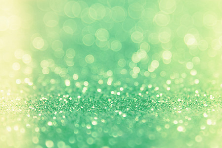 Green glitter abstract background with bokeh defocused lights.の写真素材