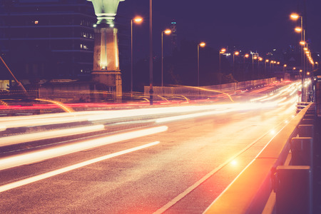 Vintage image style . Light trails of cars and twilight with sunset over on the Rama 8 bridge in Bangkok, Thailand.の写真素材