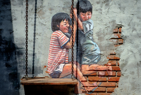 BANGKOK, THAILAND - July 1, 2017: STREET ART Painting on the the wall two cute little sisters having fun on a swing together in Traditional Ban Bangkhen Museum in Bangkok Thailand.のeditorial素材