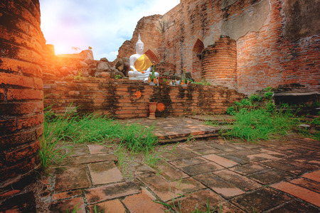 Outdoor white buddha statue in the old church with  red brick wall at Wat Kudi Dao in Ayutthaya historical park, Thailand. Vintage photo effect.のeditorial素材