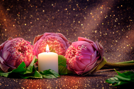 Vintage image style on pink  water lily or lotus flower folding thai style with white candle light  for worship with red bokeh background.の写真素材