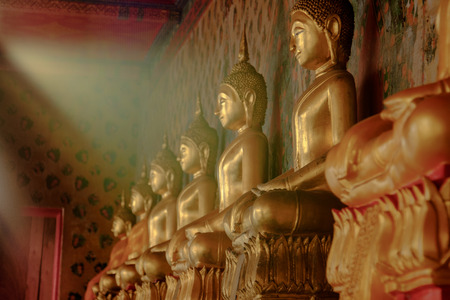 Row of golden buddha statue with natural sunlight effect at Wat Arun, Bangkok Thailand. Landmark of Thailand and asia.のeditorial素材