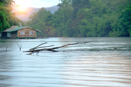 Rain on Stump in the river and houseboat at kwai river landscape in kanchanaburi, Thailand.の写真素材