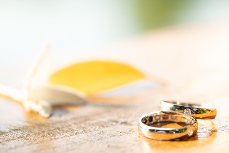 White Gold wedding rings on a wooden background.の写真素材
