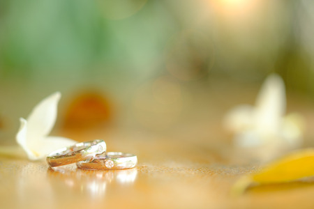 White Gold wedding rings on a wooden background.の写真素材