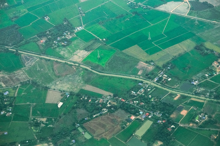 Aerial photo from a plane, top view, field roads and green field and farm in Thailand.