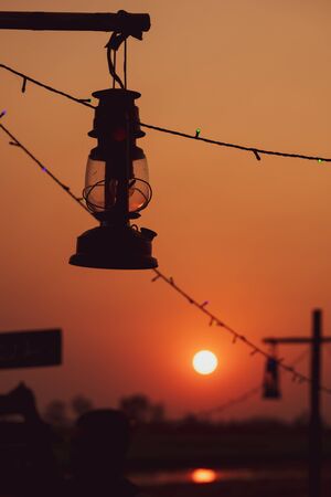 vintage oil lamp  with the Sun is going to fall. Evening. light after Sunset.の写真素材