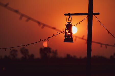 vintage oil lamp  with the Sun is going to fall. Evening. light after Sunset.の写真素材