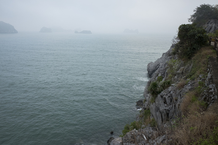 Vietnam, halong, catba. Rocky island in azure sea. Blue cloudless sky. Smaller islands in backgroundの写真素材