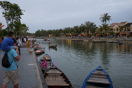 HOI AN, VIETNAM. A view of the Hoi An Thu Bon River. Buildings, boats, reflections and locals can be seen.のeditorial素材