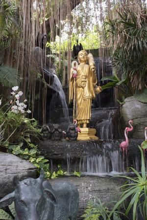 Golden Buddha statue and small artificial waterfall at the Golden Mount at Wat Saket in Bangkok, Thailand.の写真素材