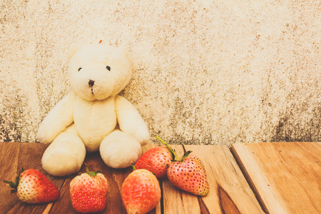 Teddy bear,Strawberry on a wooden, process color with Vintage Tones. Focusing on bear.の写真素材