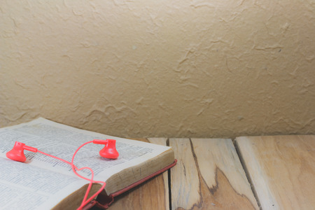 Earphone and a book on wooden. Process color with vintage tone.の写真素材