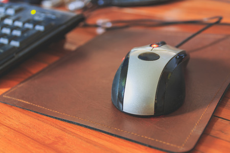 computer mouse on a wooden table, selective focus, process color with vintage tone.の写真素材