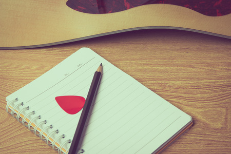 notebook and acoustic guitar, vintage tone process.の写真素材