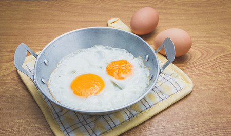 fried eggs in a small pan, thai local food.の写真素材