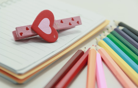 heart on a note book and colour pencilsの写真素材