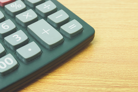 calculator plus button on a wooden.
