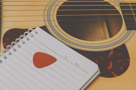 notebook on acoustic guitar, vintage tone process.の写真素材