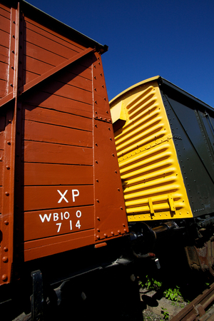 Brightly colored vintage yellow and red train carriages connected to a steam train