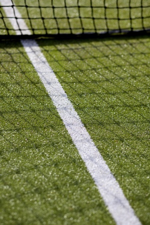 Green tennis court with net and white line markingの写真素材