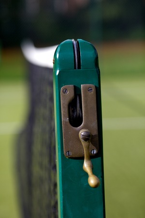Tennis court net with green post with handle to move net higher or lower.の写真素材