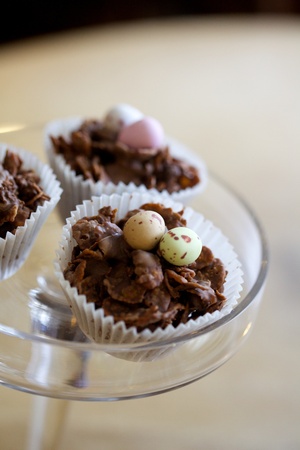 Three chocolate cornflake cake with mini eggs on a cake standの写真素材