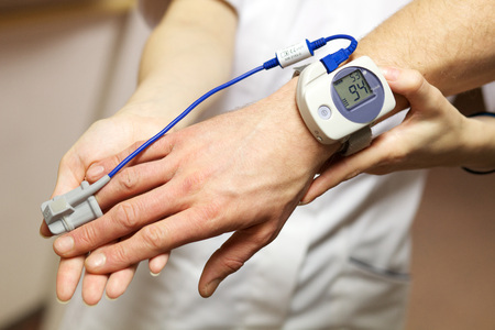 A nurse uses a pulse oximeter to monitor a patients oxygen saturationの写真素材