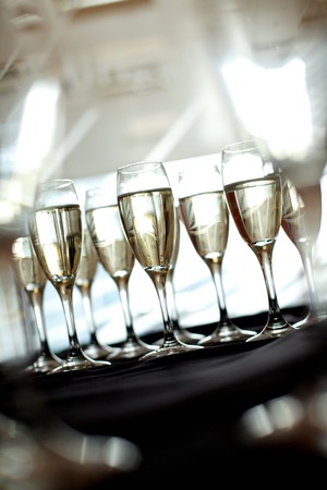Nine glasses of champagne on a silver tray at a hospitality evening functionの写真素材