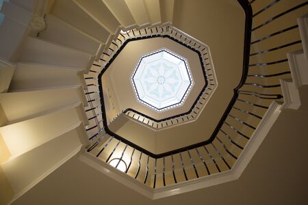 View from the bottom of a spiral staircase looking up to the centre point in the roof of an art deco window,の写真素材