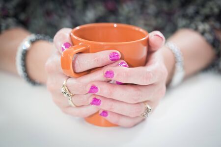 Holding a Orange mug in cupped hands,の写真素材