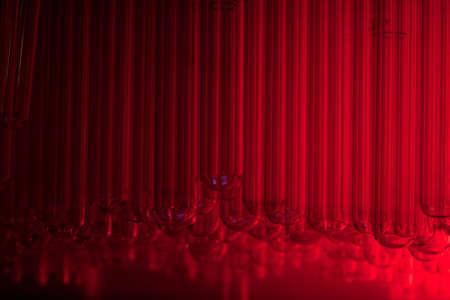 Collection of lab test tubes lit up by a red light,の写真素材
