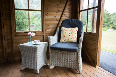 Wicker chair and table in a summerhouseの写真素材