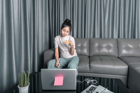 Asian women holding credit cards and notebook, laptop To pay the bills. online payment conceptの写真素材