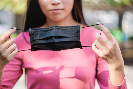 Woman wearing an anti virus protection mask black to prevent from virusの写真素材