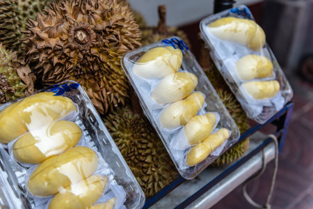 Both durian fruit and packaged fruits are displayed for sale. Durian is known for its pungent aroma and unique taste. and is often called "King of Fruits" in Southeast Asia The outer shell has sharp thorns.の写真素材